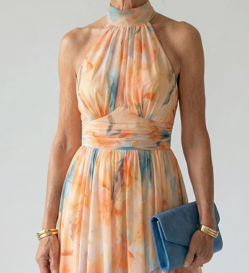 Srednje dolga Alma Ljubljana obleka Elin s halter izrezom, elegantna in modna, prikazana na modelu.