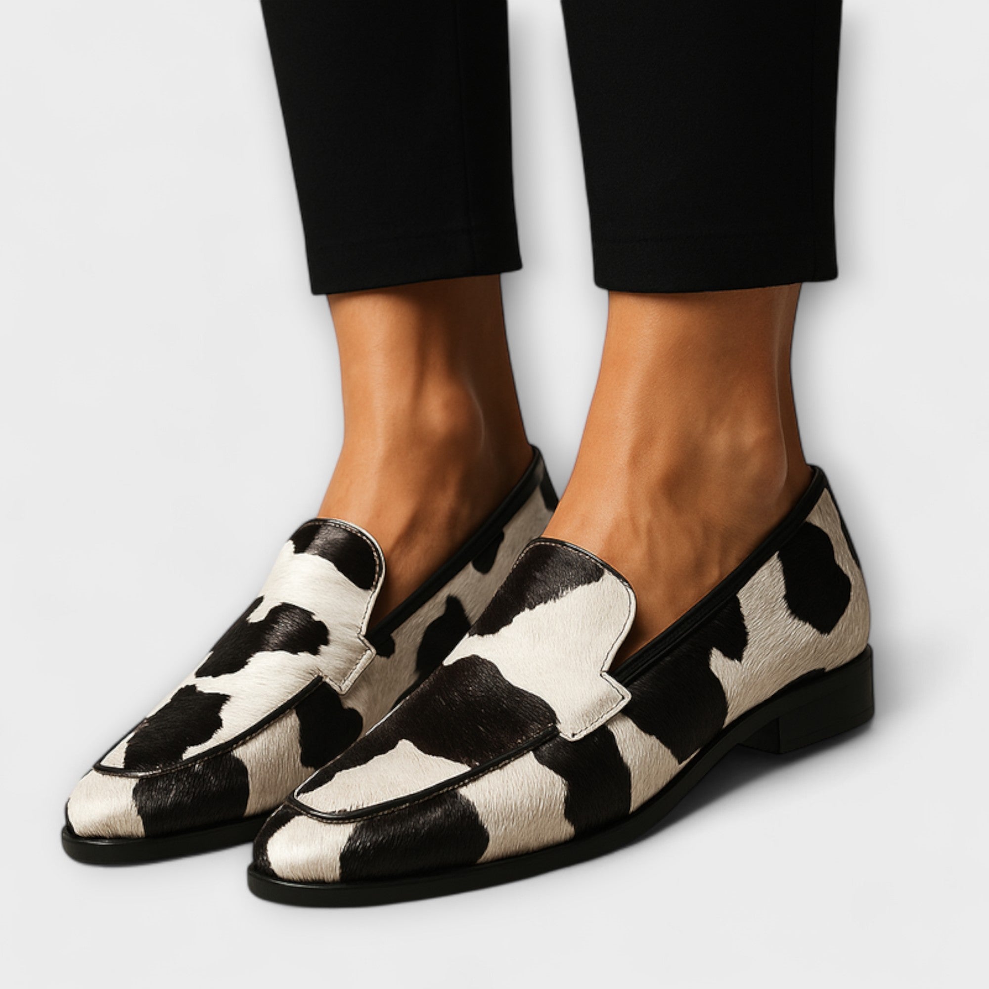Sodobni mokasini Margot™ Alma Ljubljana, črni usnjeni čevlji z gladko površino in rahlim podplatom na beli podlagi.