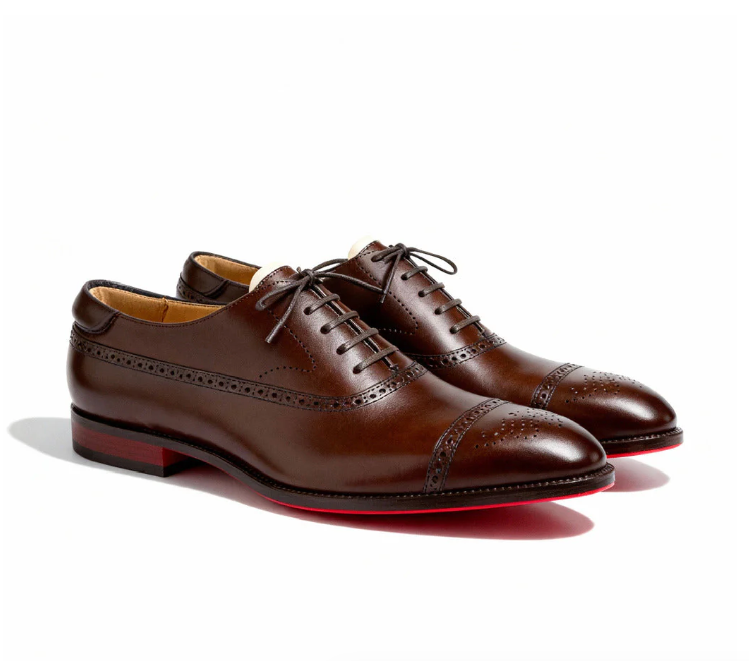 Čevlji Matej Oxford Royal Brogue znamke Mila Ljubljana, rjavi usnjeni moški gležnarji z brogue detajli na beli podlagi.