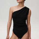 Črna bodysuit Flair od Mila Ljubljana, elegantna obleka s prilagodljivim krojem, prikazana na modelu.