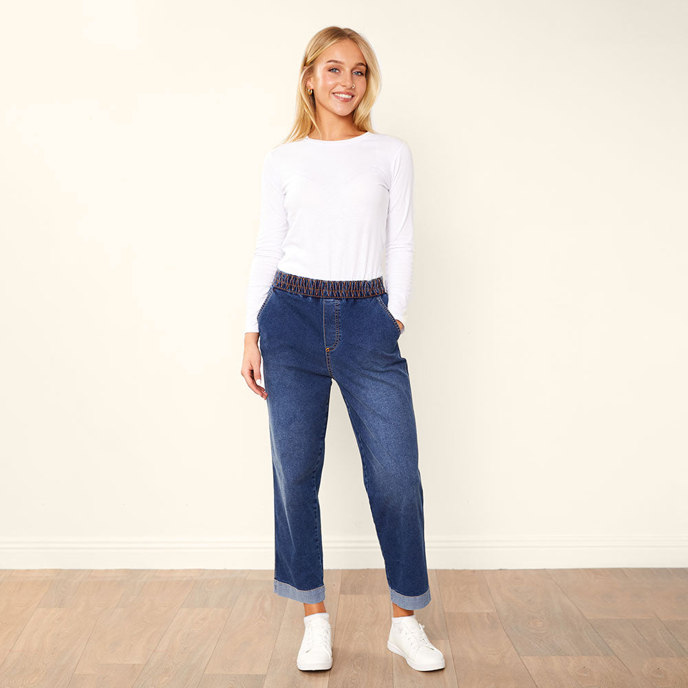 Modre denim kavbojke Kia Mila Ljubljana, ravne in udobne, s klasičnim oprijetim krojem, na beli ozadju.