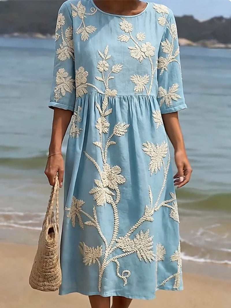 Ženska sproščena cvetlična obleka Alma Ljubljana, vintage stil, prikazana na modelu, lahkotna in udobna za poletje.