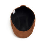 Alma Ljubljana klasična suede beret v rjavi barvi, prikazana na glavi modela, elegantno in modno dodatno za glavo.