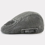 Modra Alma™ denim kapa z ravnim krojem in zavezovalnim trakom, prikazana na sliki.