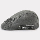Modra Alma™ denim kapa z ravnim krojem in zavezovalnim trakom, prikazana na sliki.