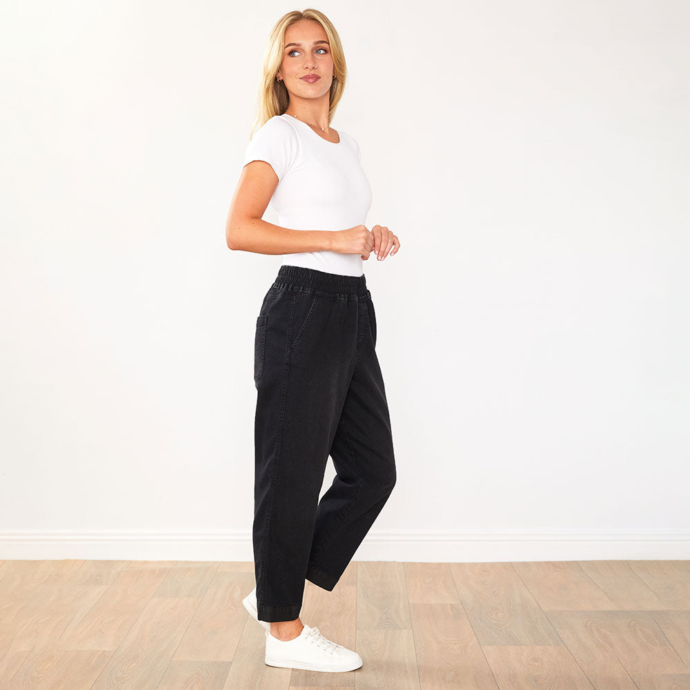 Udobne črne traperice Kia podjetja Mila Ljubljana, casual stil, prikazane na modelu.